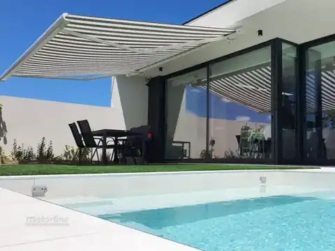 Store banne ouvert sur une terrasse avec piscine